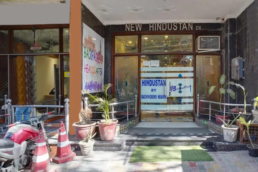The entrance of Hindustan by Backpackers Heaven, with the hotel sign and plant pots on the pavement